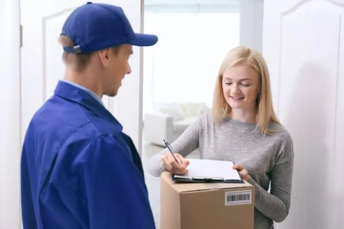 Nadanie paczki do Niemiec pod drzwiami — kierowca odbiera przesyłkę, nadawczyni potwierdza dane odbiorcy